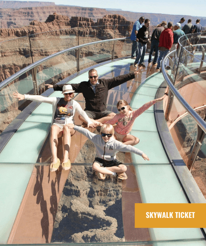 A family poses with arms outstretched on the Grand Canyon Skywalk, showing the canyon below.