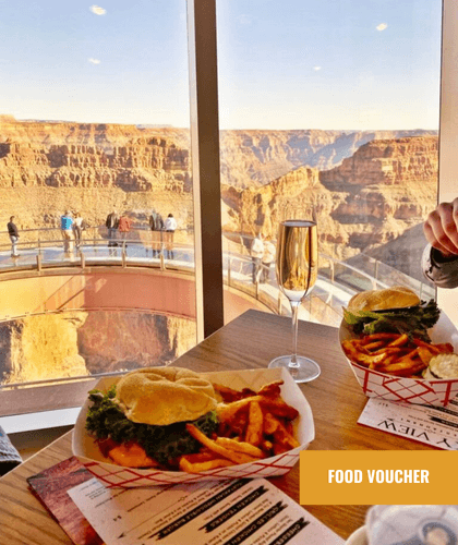 A meal with fries and a drink on a table, with a view of the Grand Canyon Skywalk.