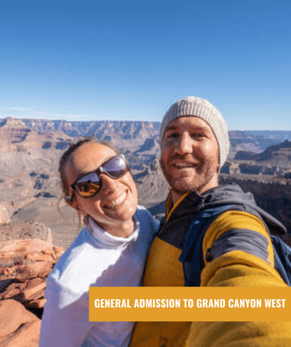 A happy couple taking a selfie with the Grand Canyon in the background.
